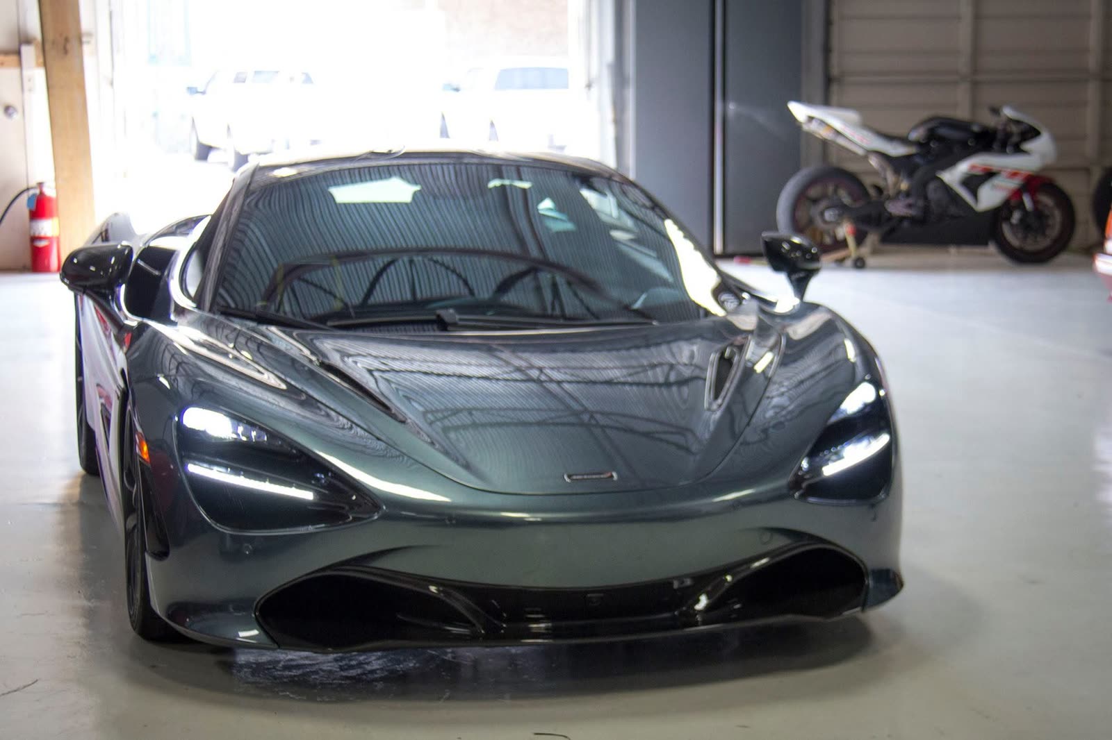 The front of a gray McLaren 720S in the shop